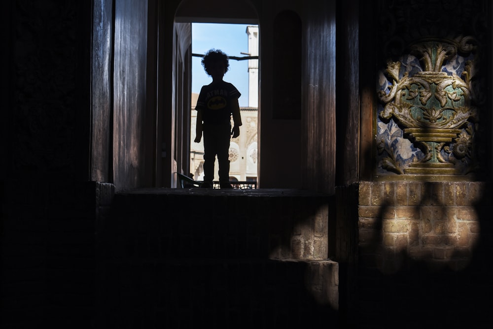 man in black jacket standing on window