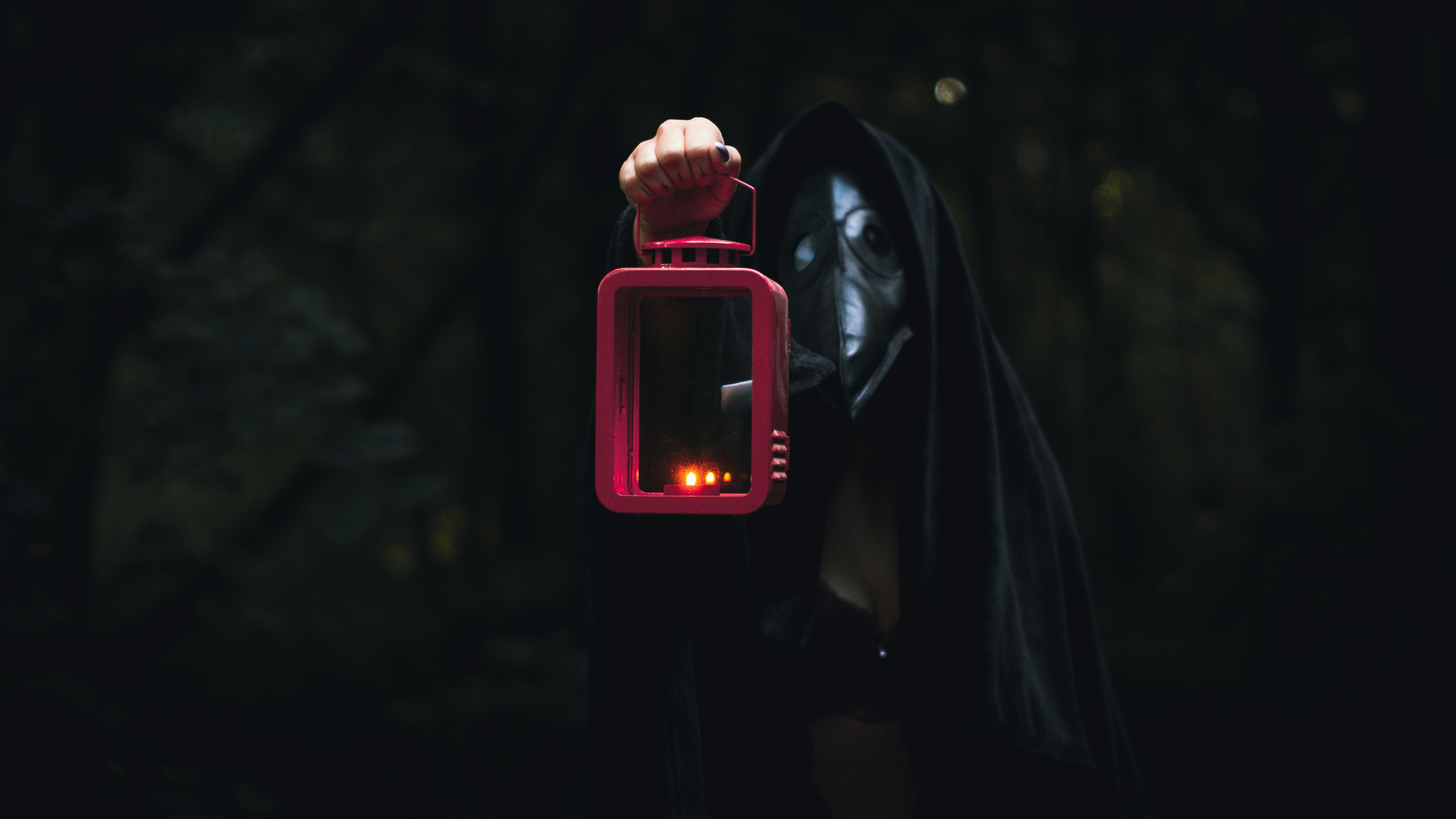 person in black hoodie holding pink smartphone