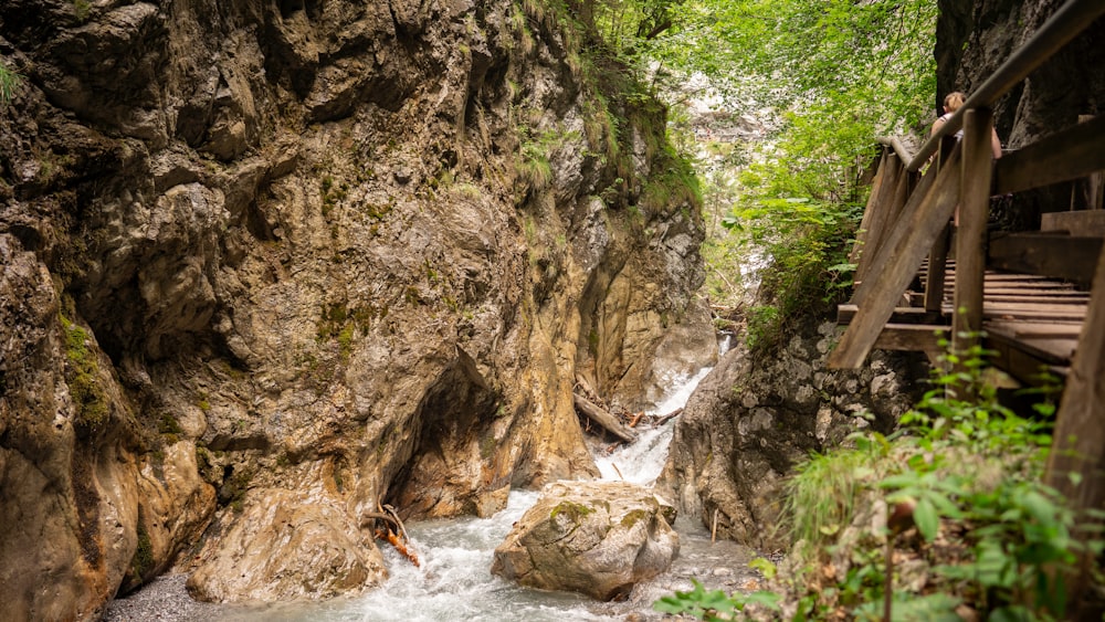 river in between rocky mountain during daytime