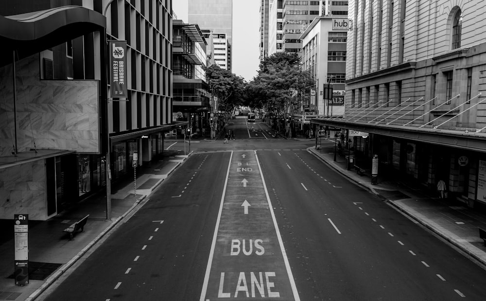 grayscale photo of a road in the middle of a city