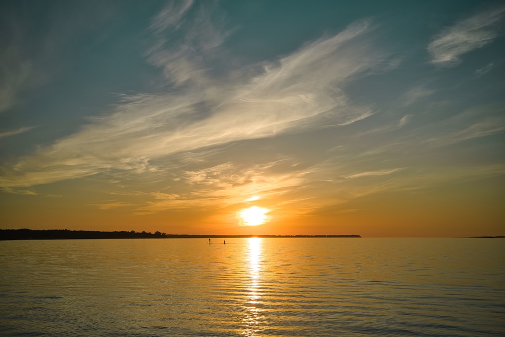 body of water under blue sky during sunset