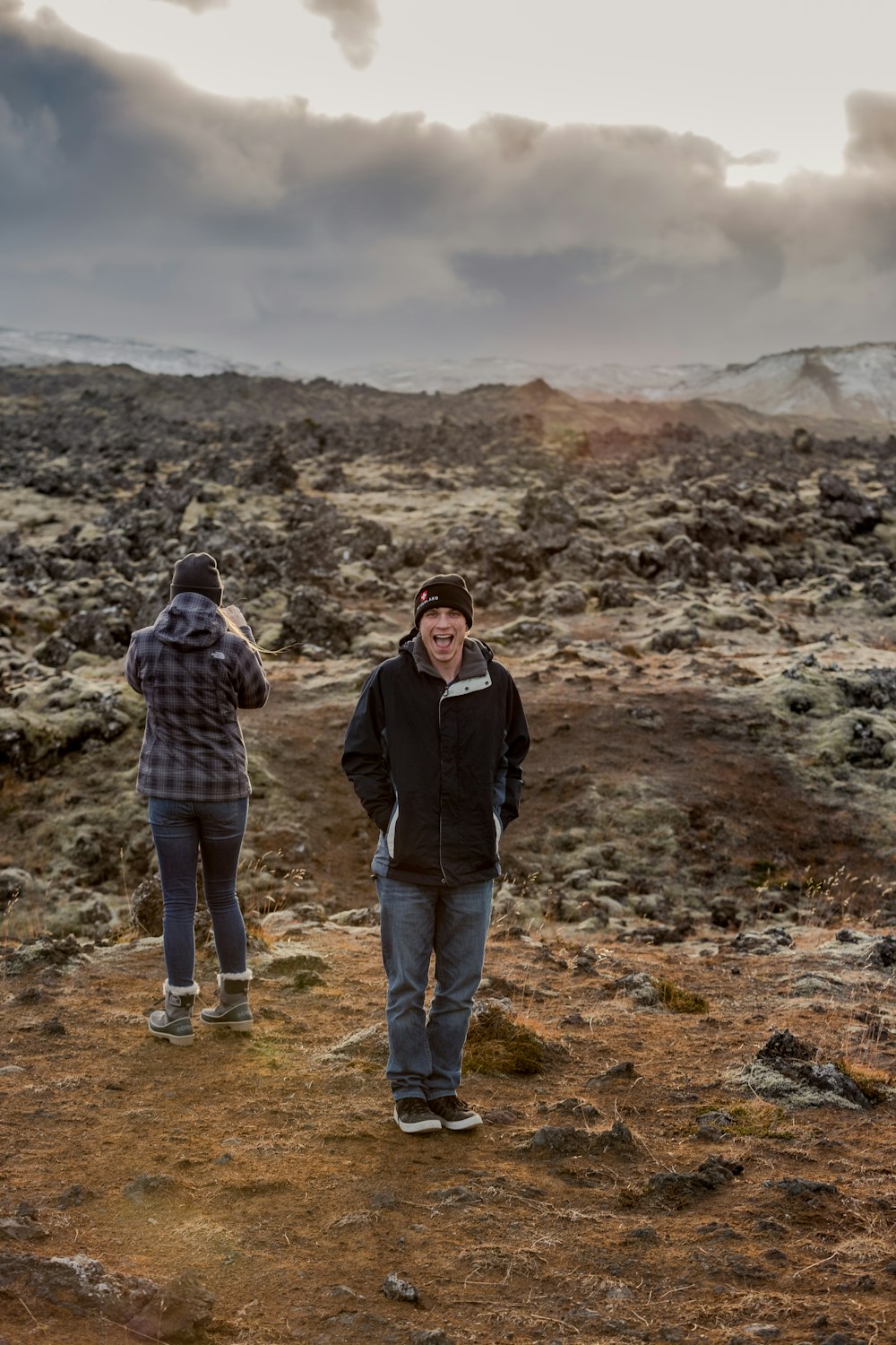 man in black jacket standing beside woman in brown jacket