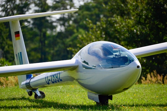 white and blue airplane on green grass field during daytime in Görlitz Germany