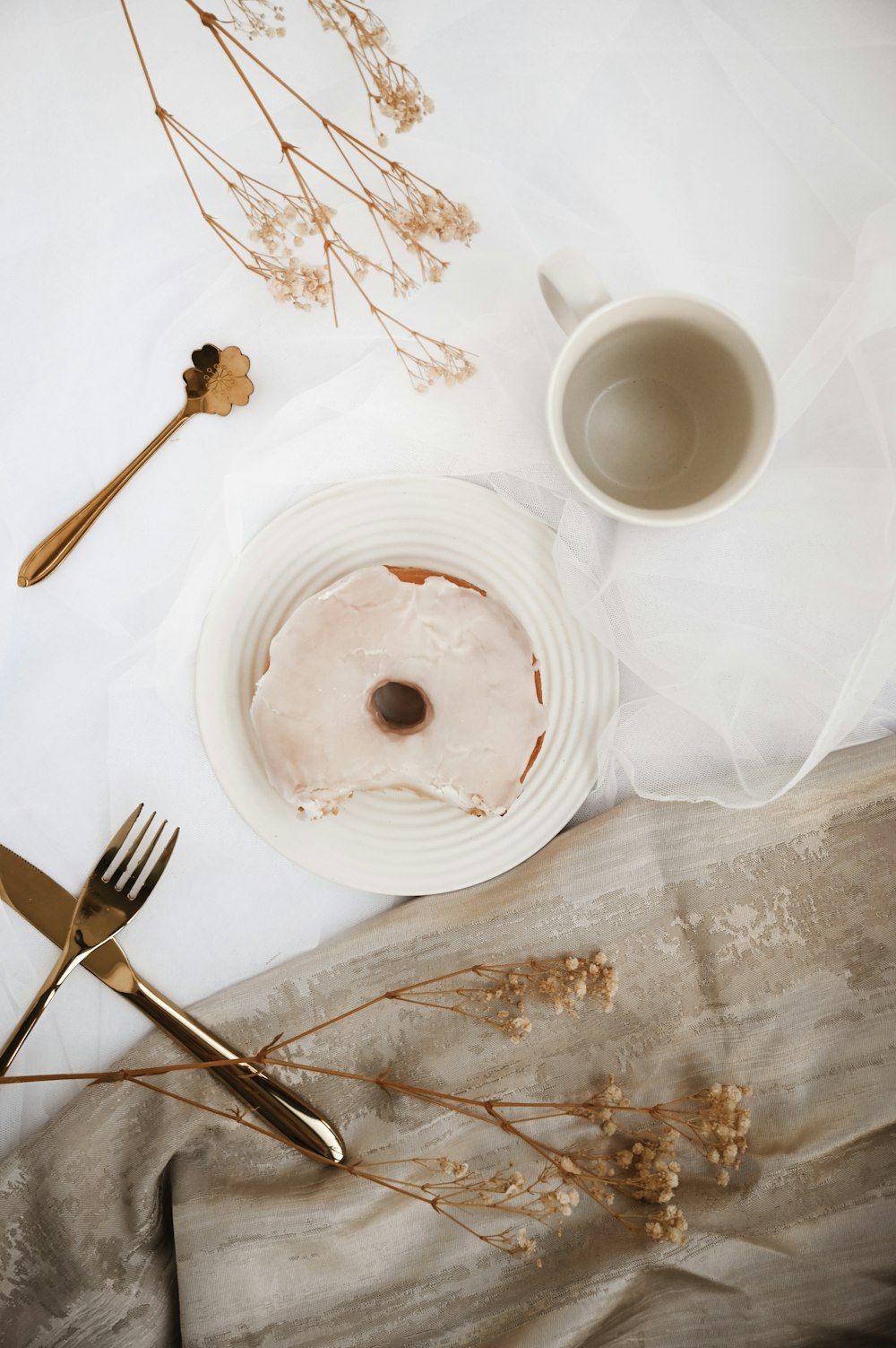 Assiette ronde en céramique blanche avec fourchette et couteau en acier inoxydable