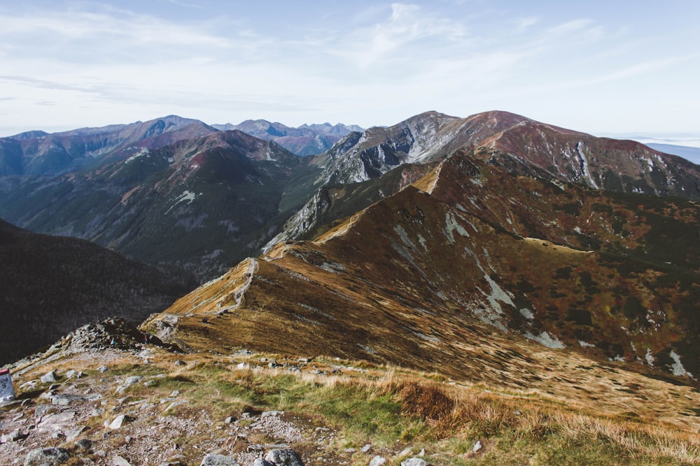 grüne und braune Berge unter weißen Wolken tagsüber