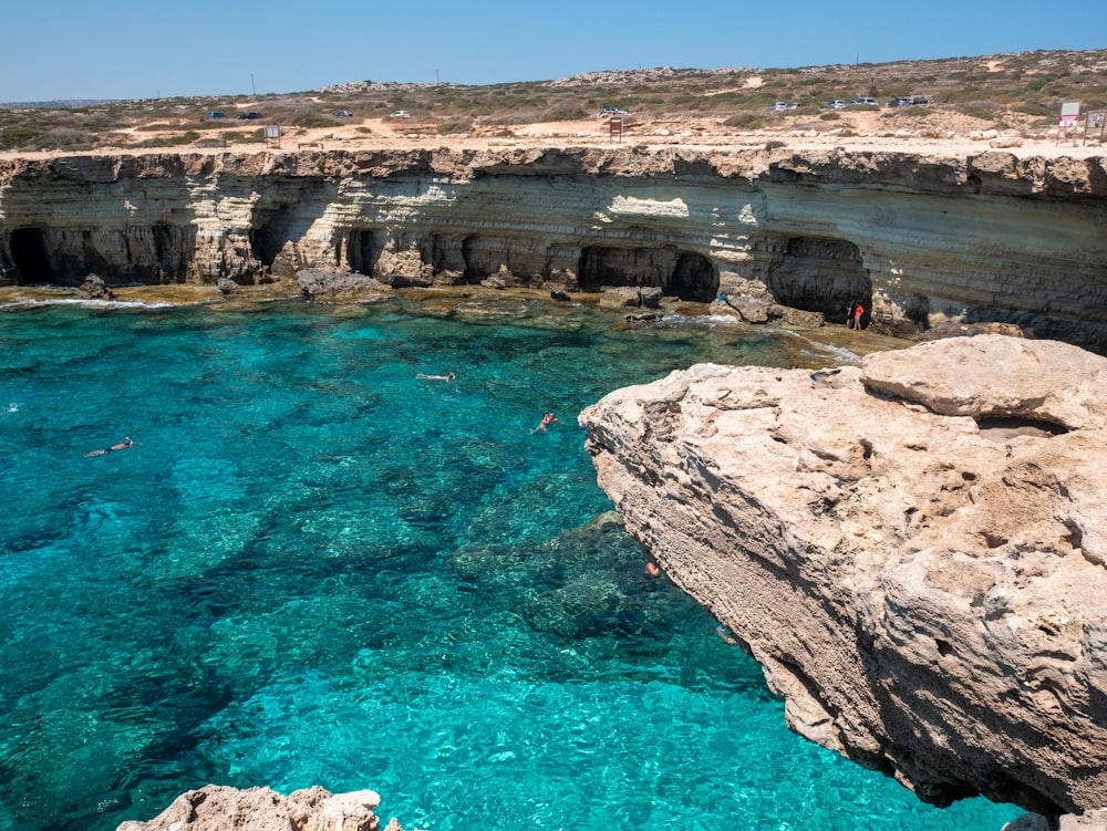 brown rock formation near body of water during daytime