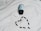 A black bottle of pills is lying on its side on a white surface, with its white cap detached. Several black capsules are arranged in the shape of a heart below the bottle.