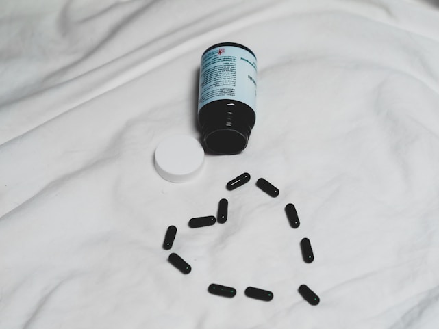A bottle of Cardio Genix capsules on a wooden table.