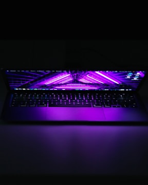 A person streaming a movie on a laptop with purple-themed interface.