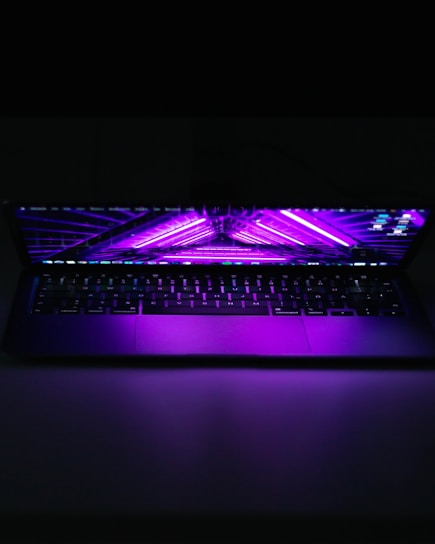 A sleek laptop emitting digital streams in purple and black tones