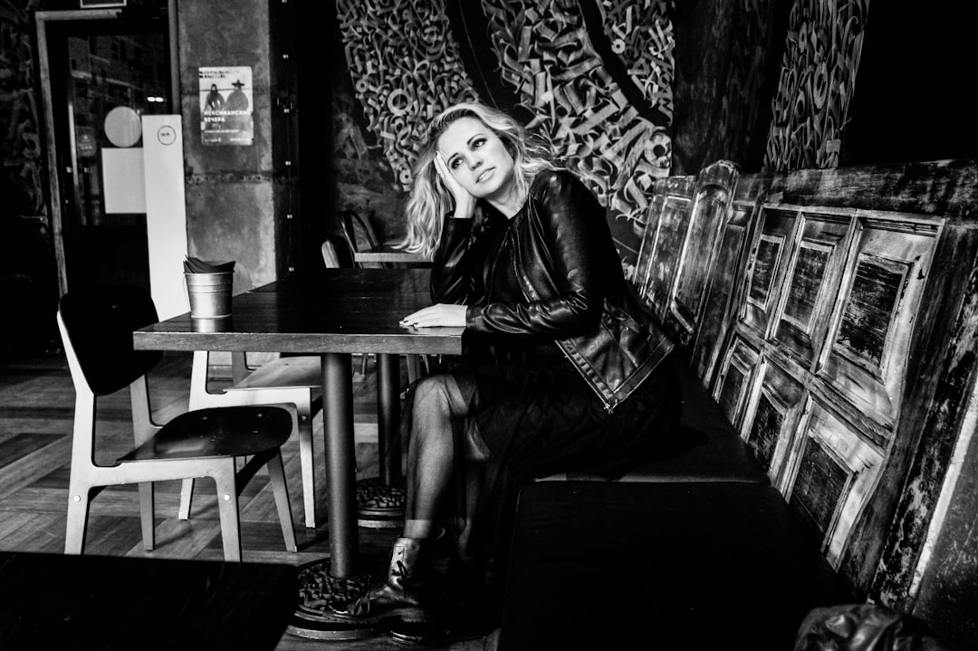 woman in black leather jacket sitting on chair