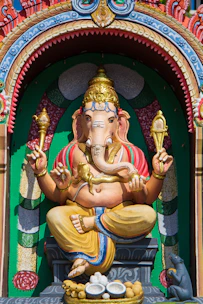 gold hindu deity statue on green and red textile
