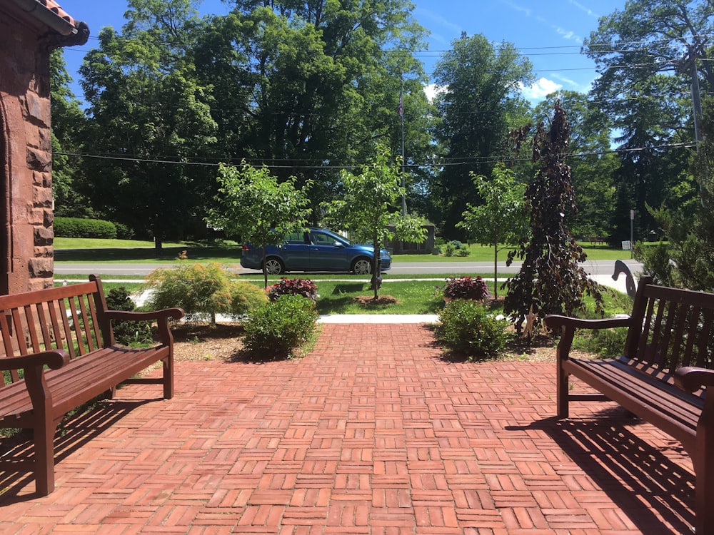 blue sedan parked near green trees during daytime