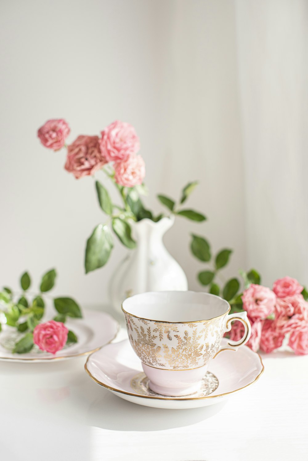 Weiße und rosa florale Keramik-Teetasse auf Untertasse