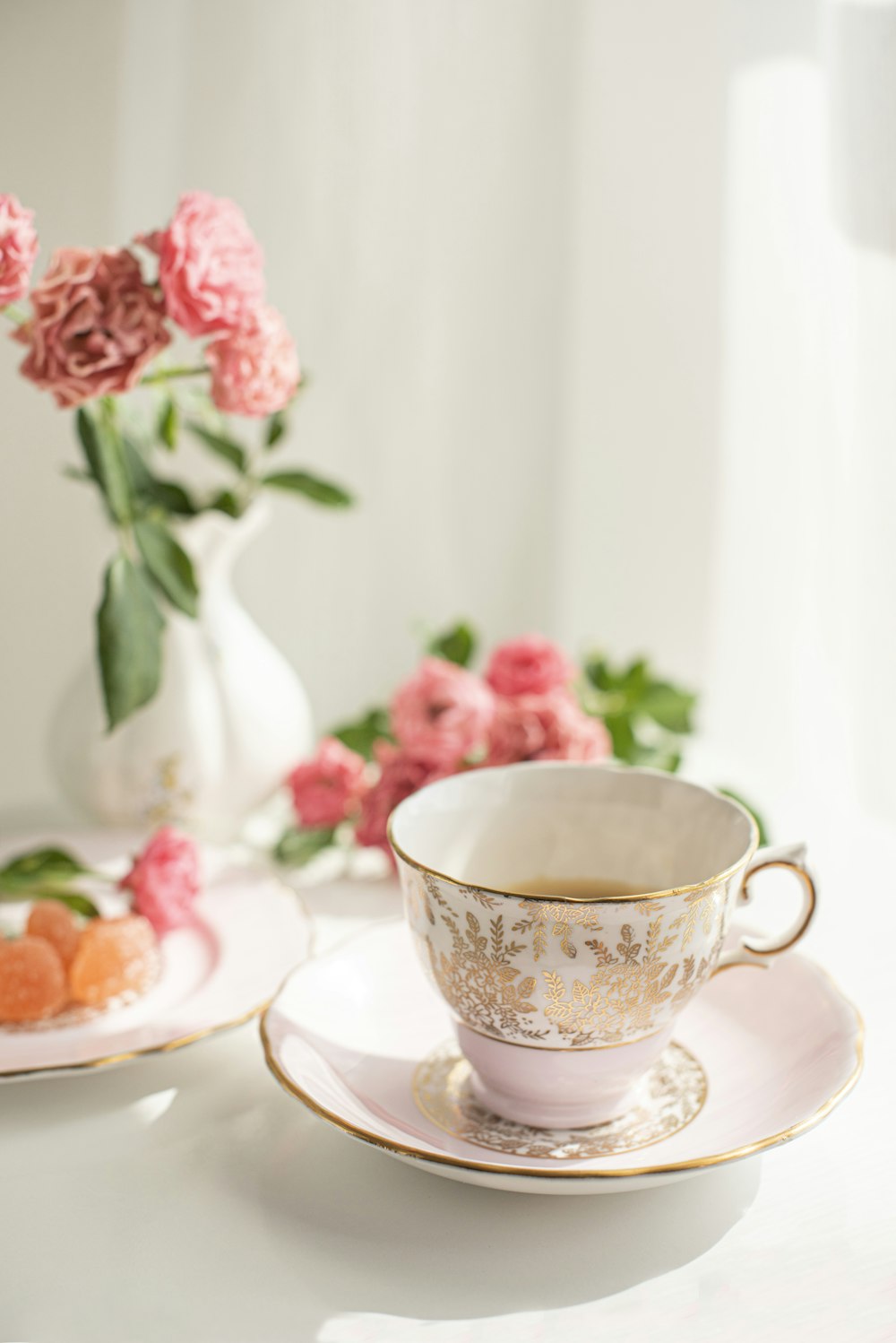 Weiße und rosa florale Keramik-Teetasse auf Untertasse