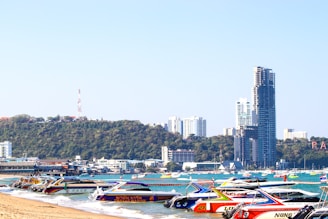 red and black boat on water near city buildings during daytime