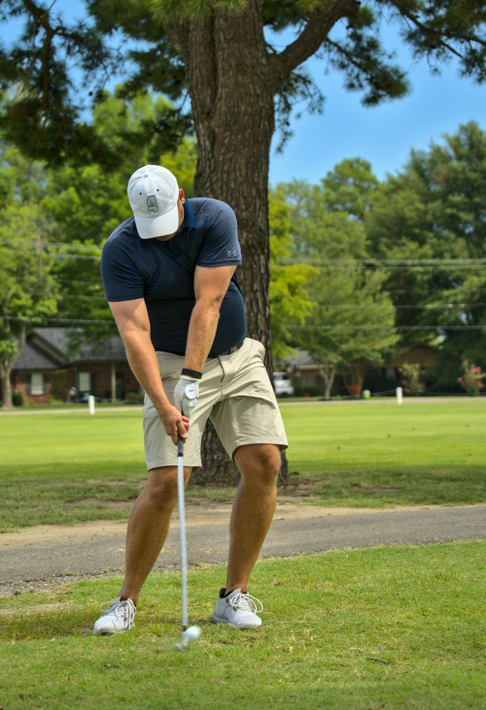 man in black t-shirt and white shorts playing golf during daytime