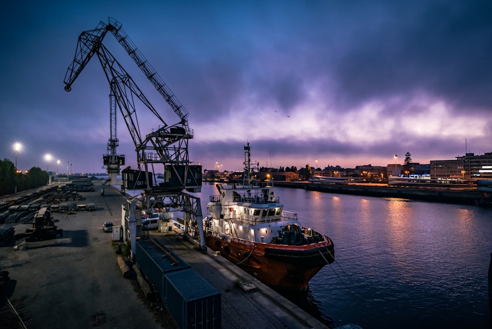 weißes und rotes Boot am Dock während der Nacht