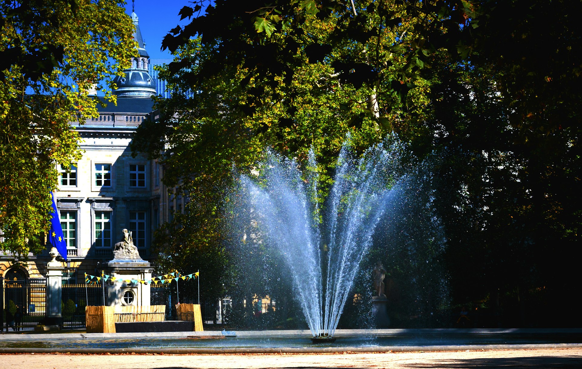 Refreshing fountain and lush greenery in a Brussels public park during the day