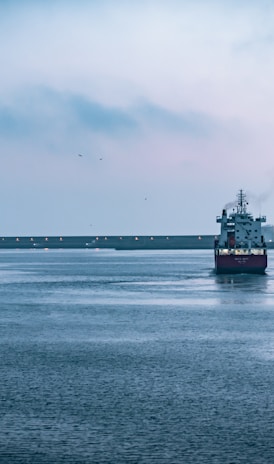 black ship on sea under white sky during daytime