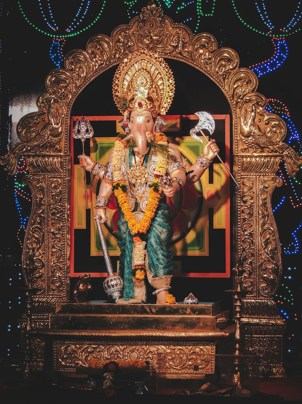 Statuetta di divinità indù in oro su tavolo di legno marrone