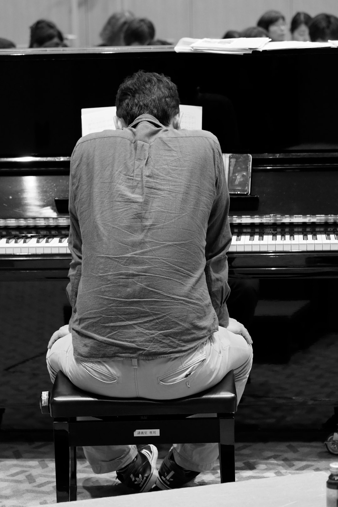 man in long sleeve shirt sitting on piano