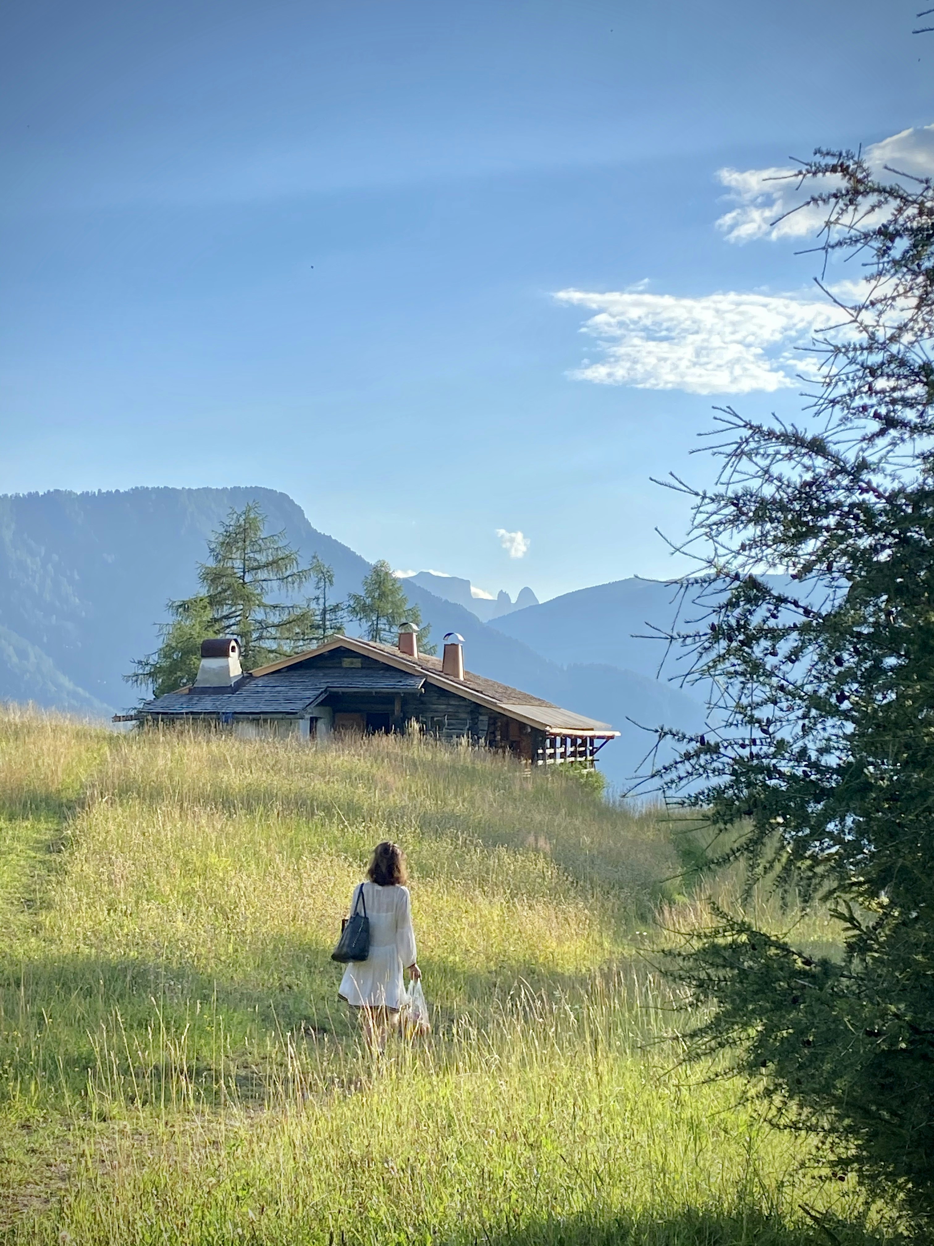 Woman in front of alpine chalet.