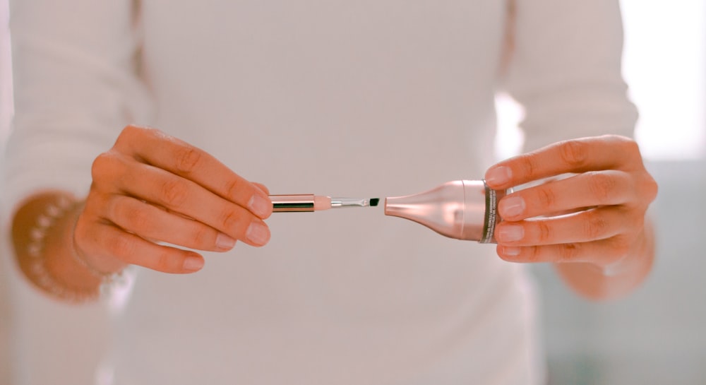 person holding silver and black hand tool