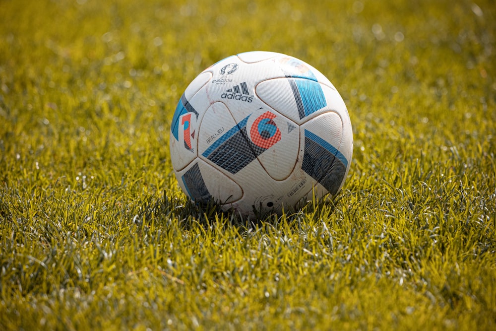 white and black soccer ball on green grass field during daytime