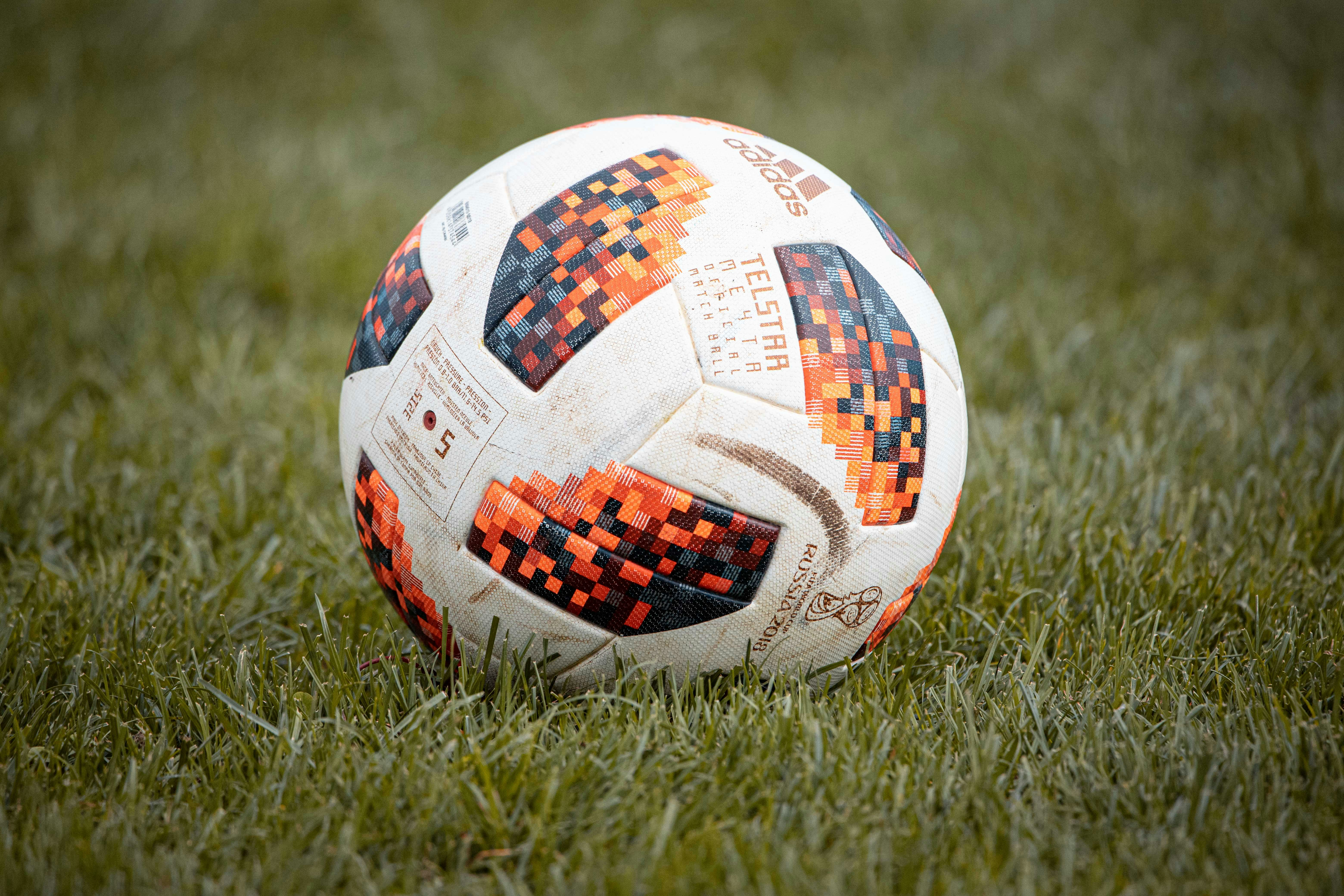 white red and blue soccer ball on green grass