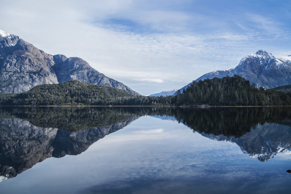 lake near mountain under cloudy sky during daytime