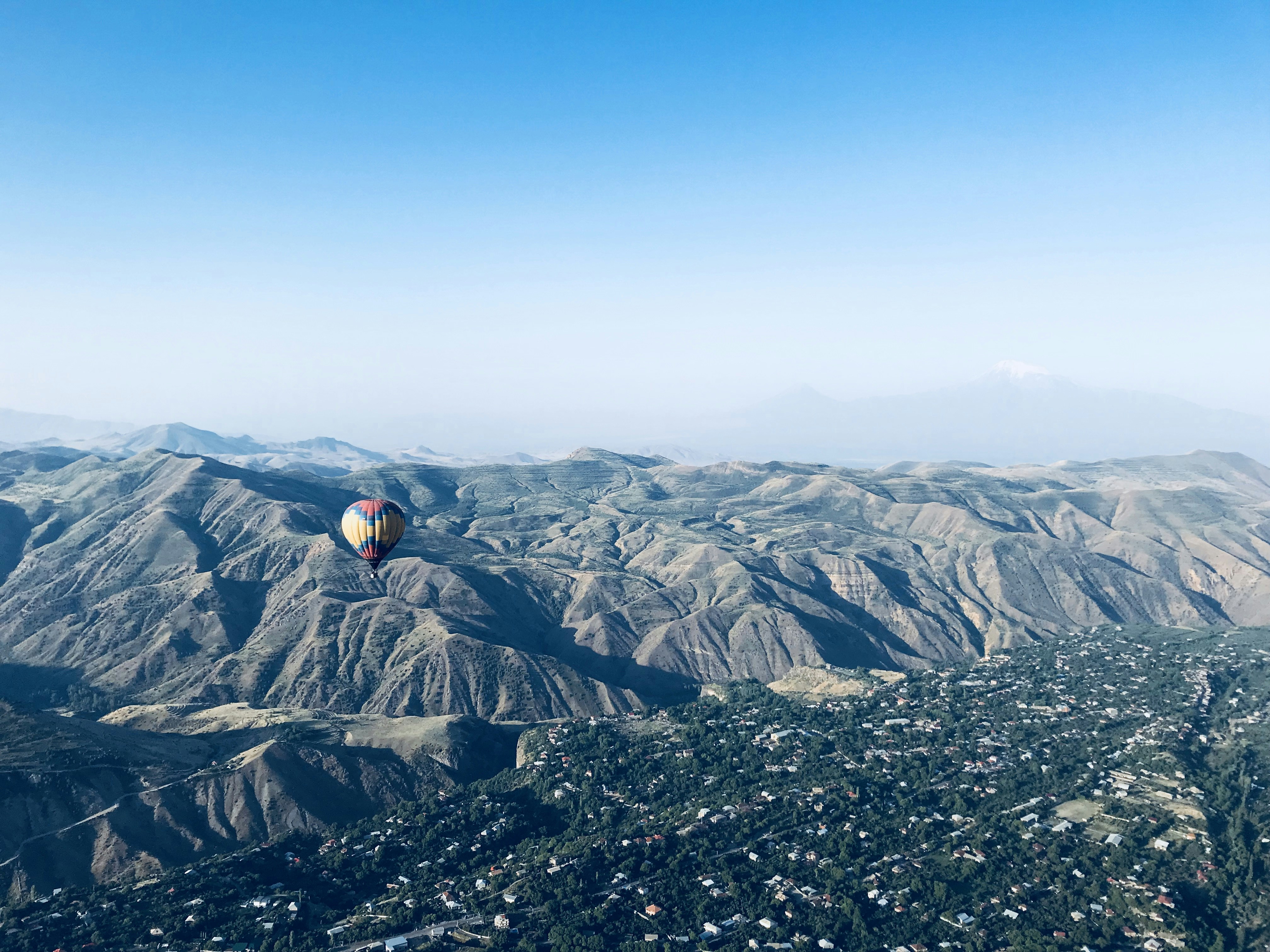 person in black jacket sitting on rock formation during daytime
