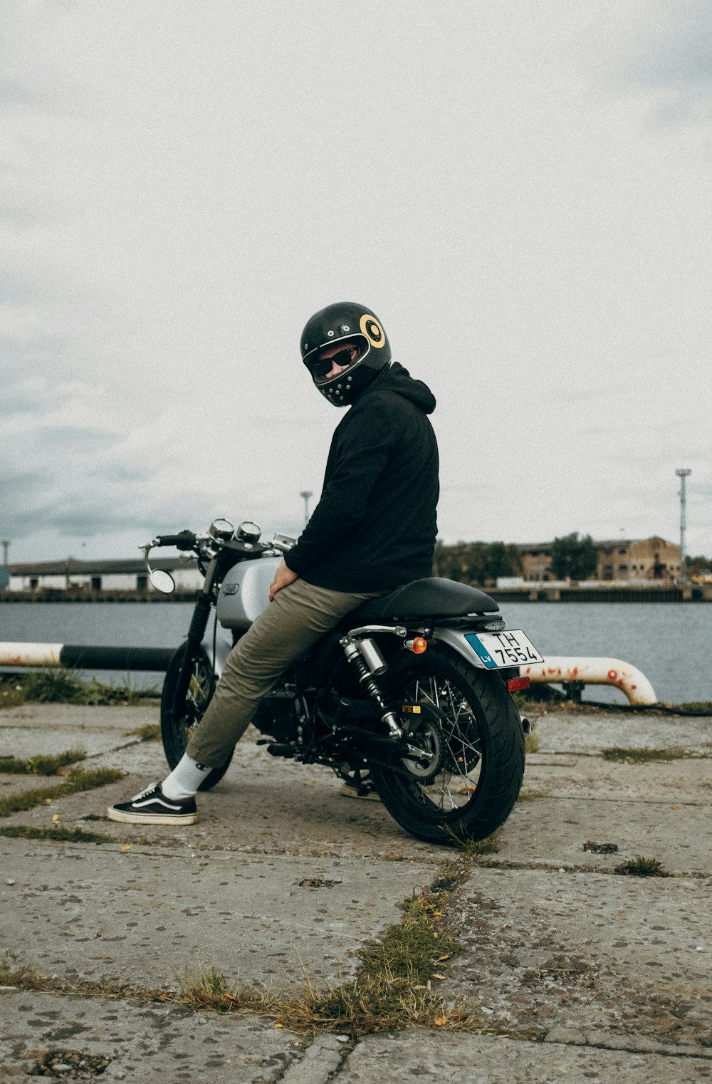 man in black jacket riding on white and black sports bike