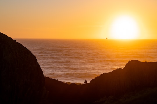 silhouette of mountain beside body of water during sunset in Seal Rock United States