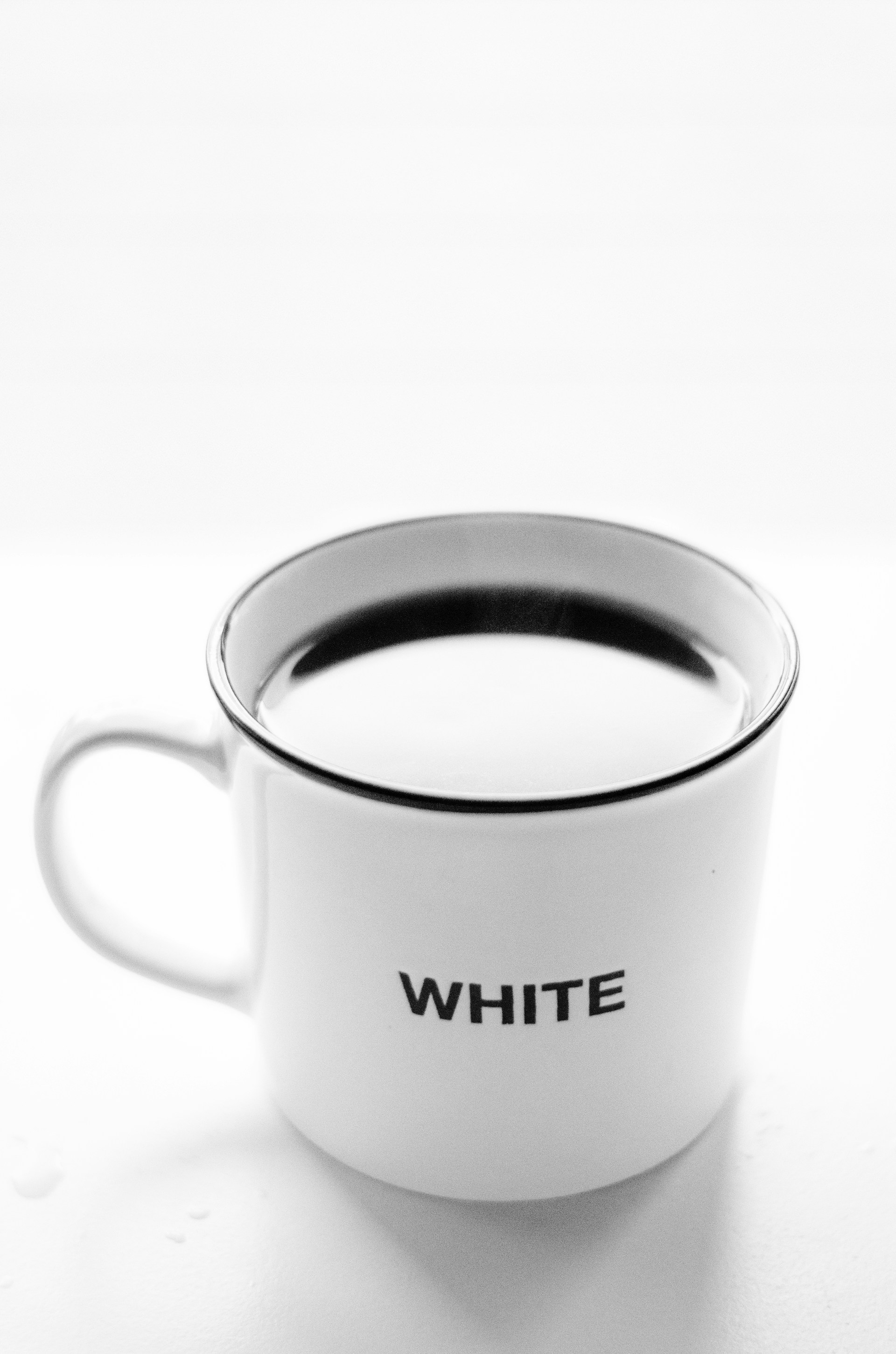 white and black ceramic mug with coffee