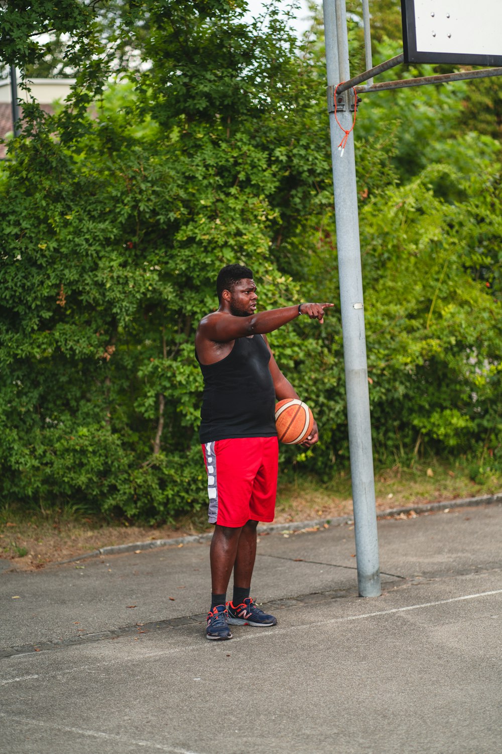 man in red shorts playing basketball during daytime