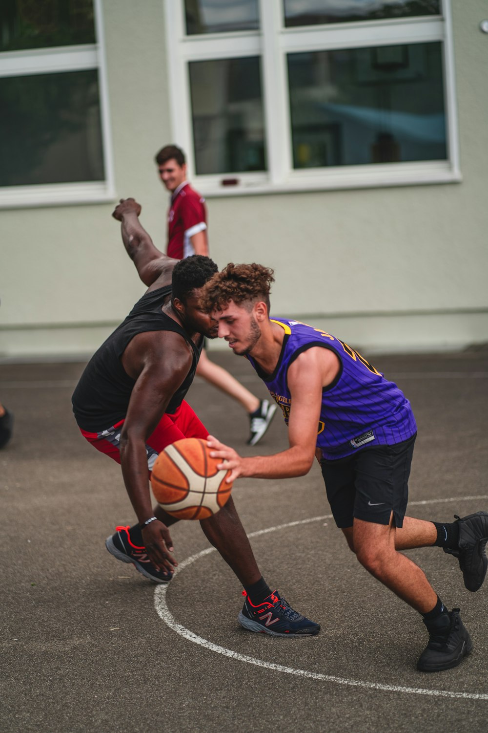 man in blue and black jersey shirt holding white and orange basketball