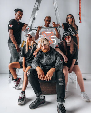Group of friends in matching streetwear posing confidently on graffiti-covered stairs.