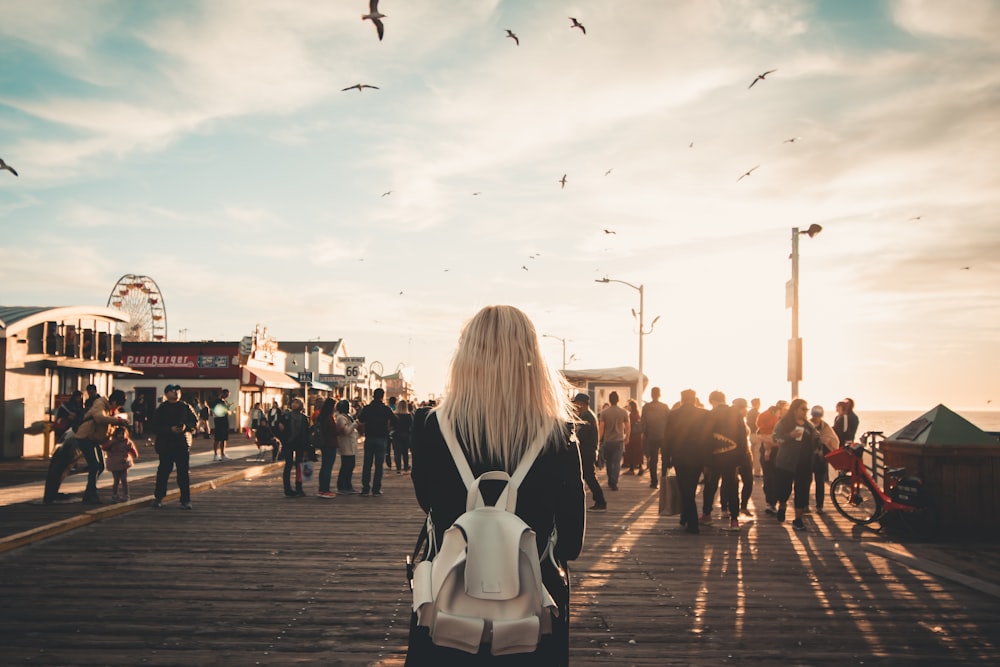 woman in white and black long sleeve shirt walking on the street during daytime