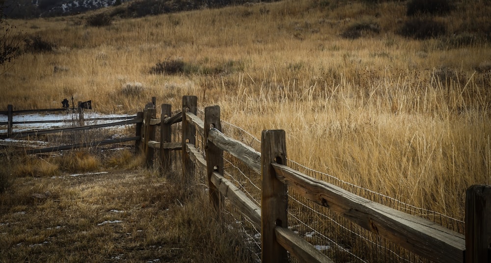 brown wooden fence on brown grass field during daytime