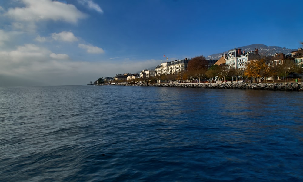 body of water near city buildings under blue sky during daytime