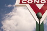 A vintage gas station sign illuminated at dusk.