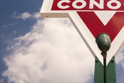A vintage gas station sign illuminated at dusk.