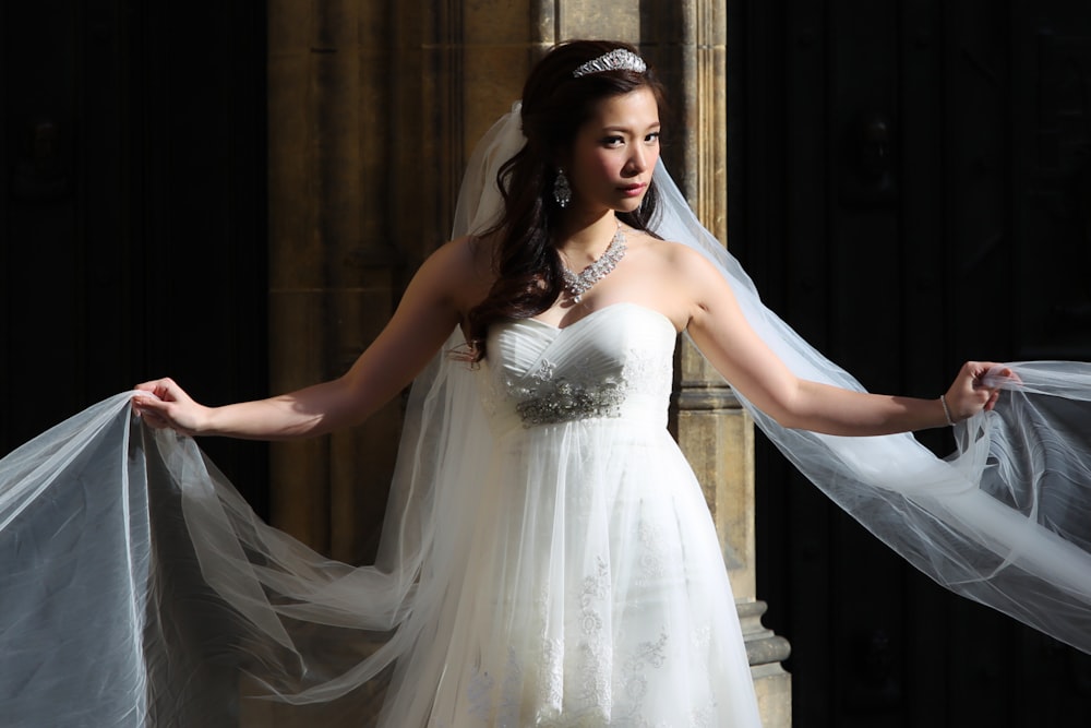 woman in white wedding dress standing on stairs