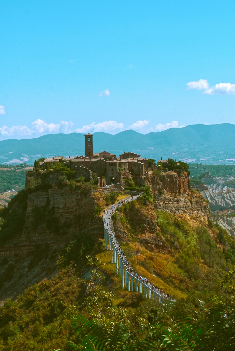 edificio in cemento marrone sulla cima della montagna durante il giorno