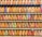 A collection of vintage train tickets displayed in rows, each ticket held in place by a metal clip. They feature various shades of orange, yellow, and blue with printed text denoting different destinations and travel information. Some tickets have bold, colorful highlights in pink and green, adding contrast to the overall muted tones.