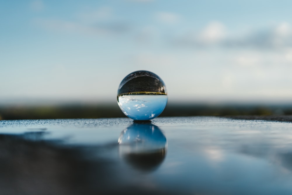 clear glass ball on gray sand