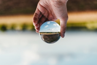 person holding clear glass ball