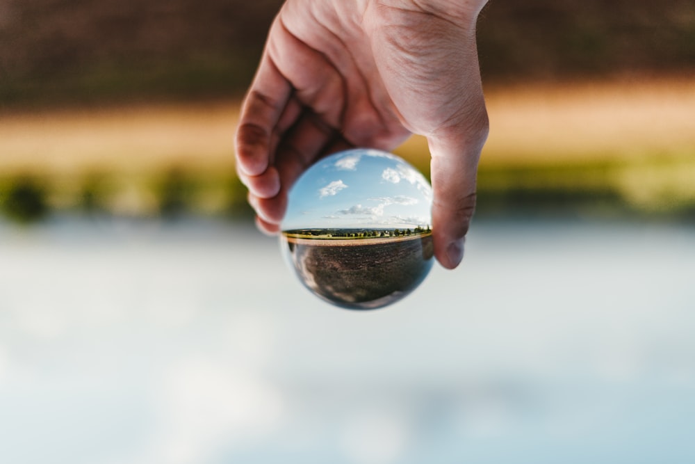 person holding clear glass ball