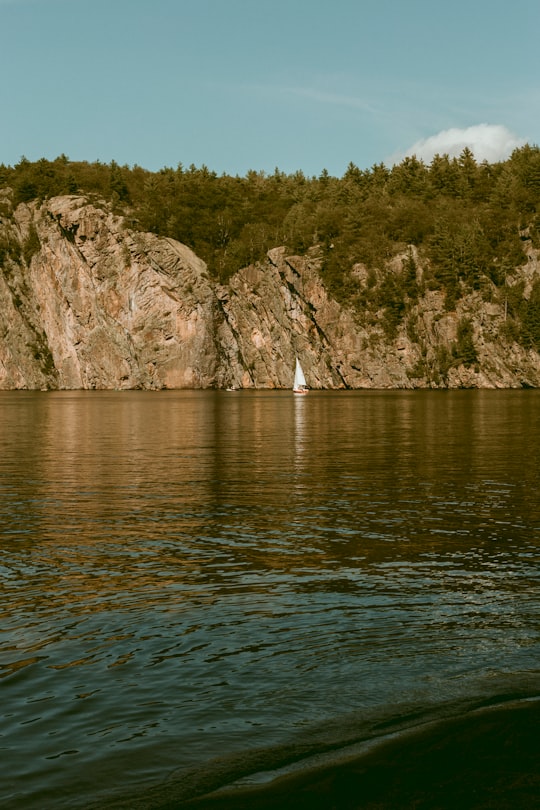 body of water near mountain during daytime in Bon Echo Provincial Park Canada